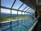 【大浴場】最上階にある広々とした大浴場。一面ガラス越しに壮大な蔵王連邦、山形の風景を望めます。