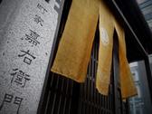 道しるべ灯篭と柿渋のれん